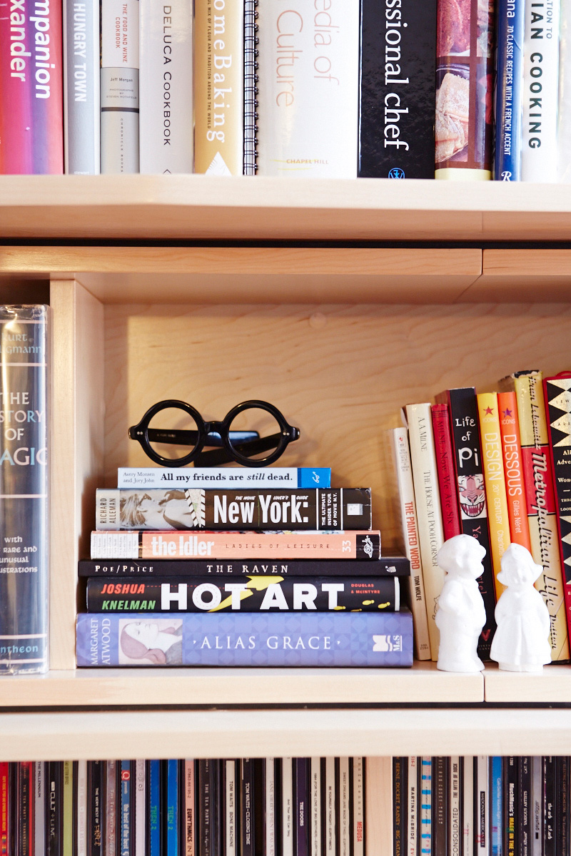 Details of the bookcase shelves featuring books and a pair of glasses.