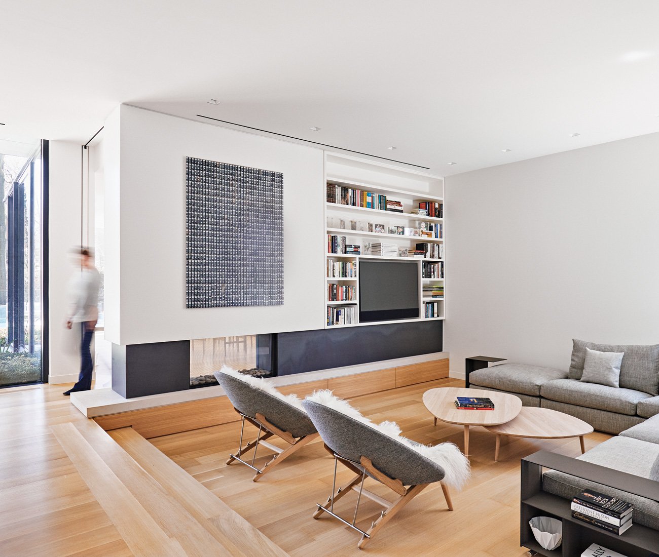 Sunken living room with a two-sided Ortal fireplace, surrounded by hot-rolled steel, Minimalist Toronto home designed by AKB architects