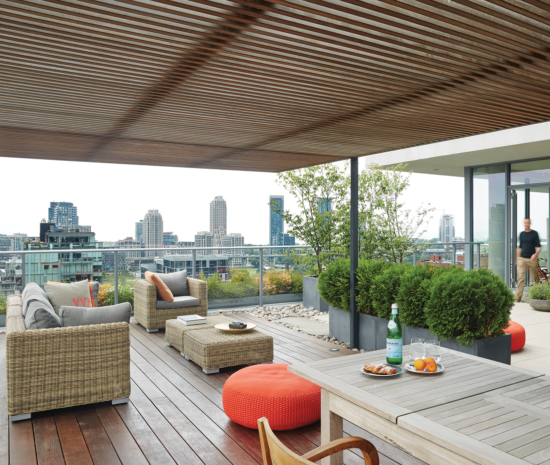Rooftop patio terrace at King and Bathurst featuring flagstone, river stone, and concrete pavers, with vibrant garden planters and ottomans. - Tom Deacon penthouse 