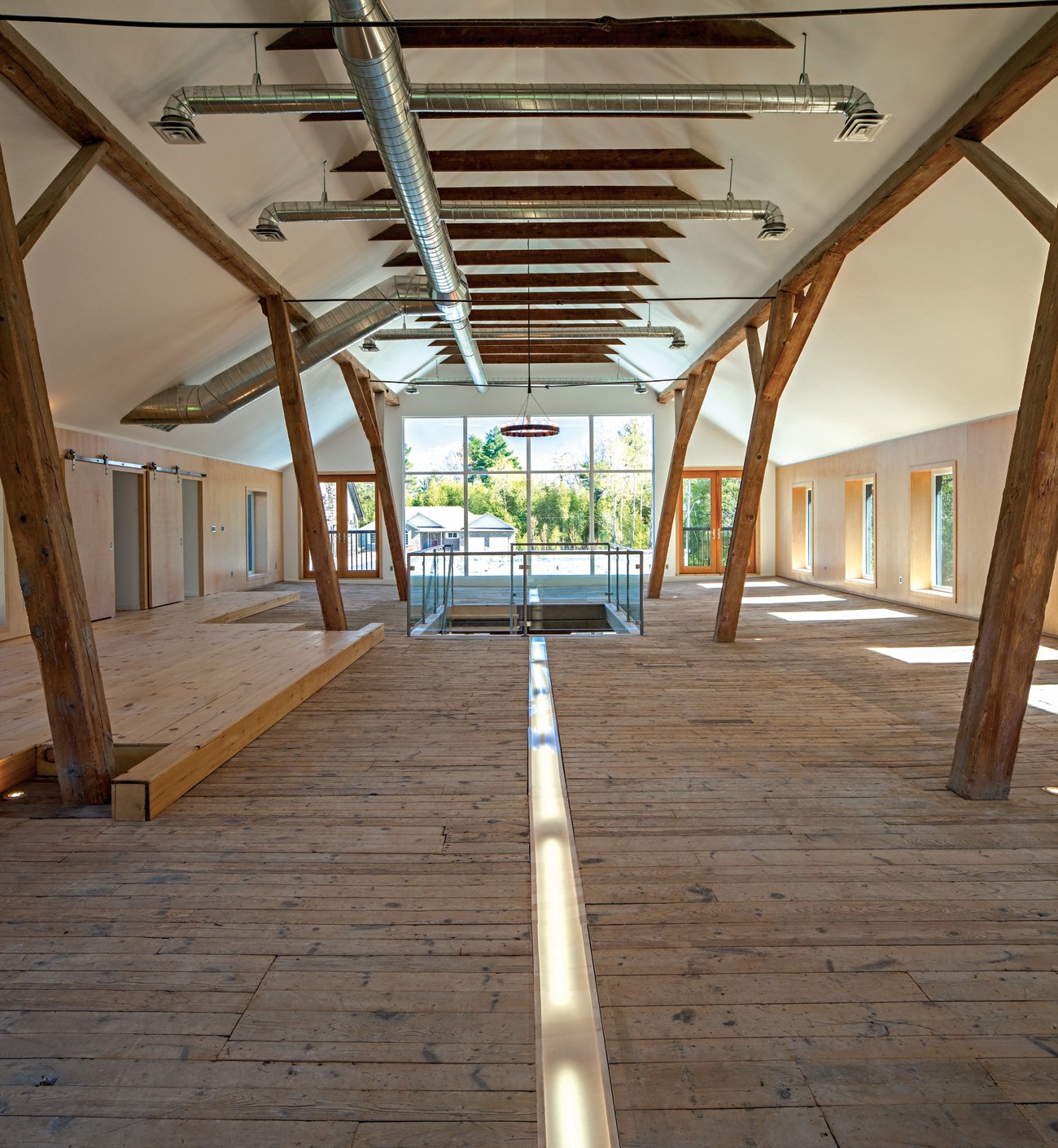 The old factory spacious second level with a 6.4-metre pitched roof, featuring a stage and embedded fluorescent lights covered in frosted Plexiglas.