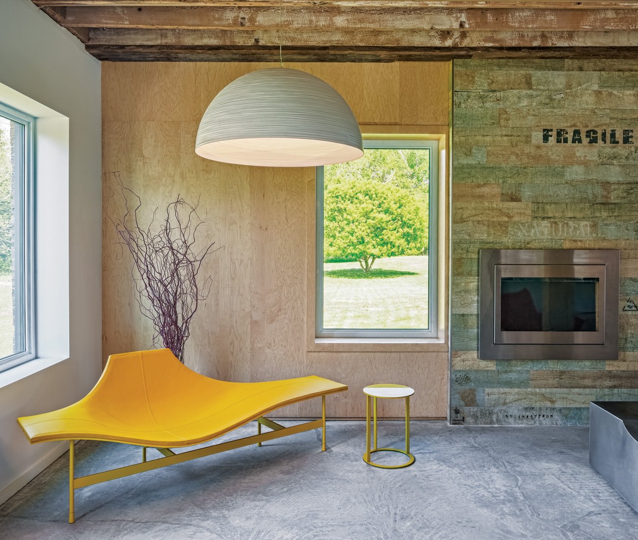 Bright furnishings contrast rustic features with porcelain tile resembling distressed wood around the built-in fireplace.