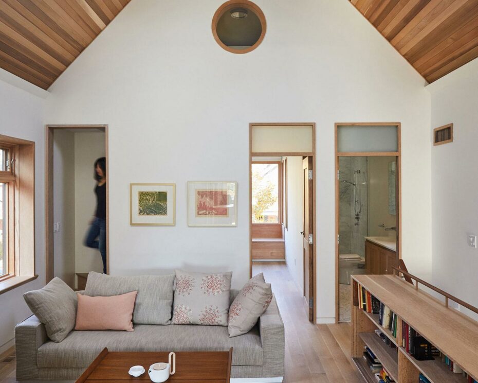 Upper-level reading room with cedar tongue-and-groove ceiling and wood-burning stove, embodying the charm of a Japanese cabin. Studio Junction design