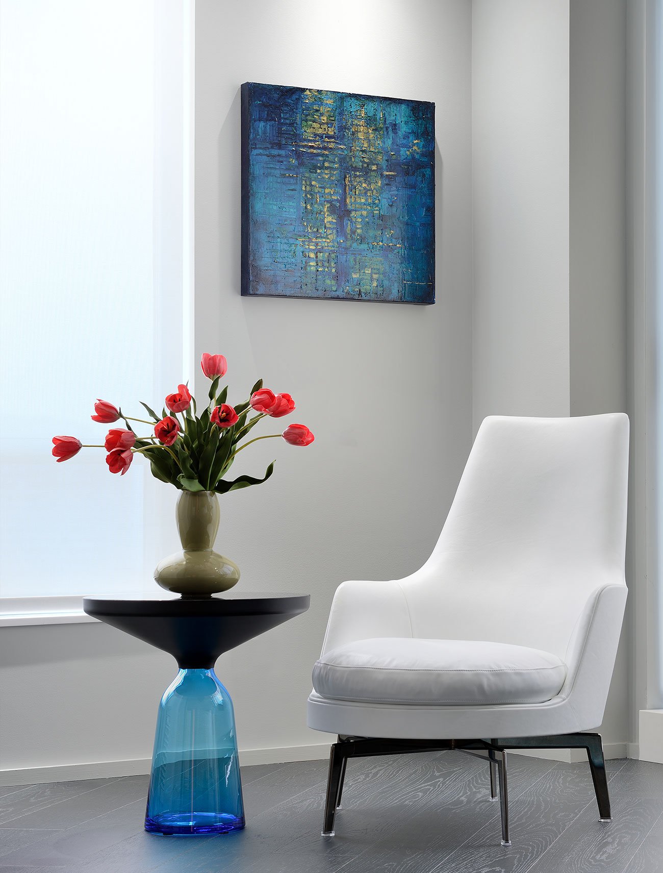 Corner with chair and side table with tulips on a vase