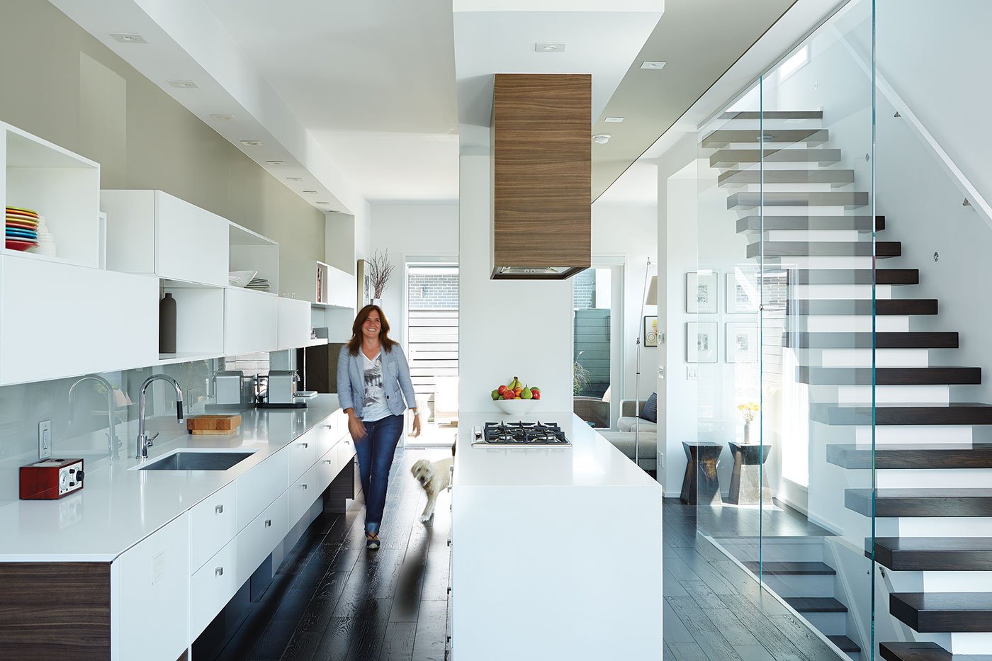 A female person with a white dog is walking in a kitchen designed by Cecconi Simone | kitchen design ideas
